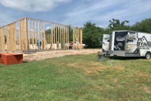 Construction site with wooden framing and Byars trailer.