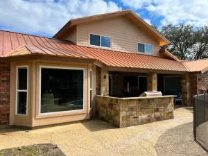 Outdoor patio with stone countertop and windows.