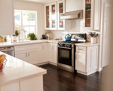 Bright kitchen with white cabinets and dark wood floors