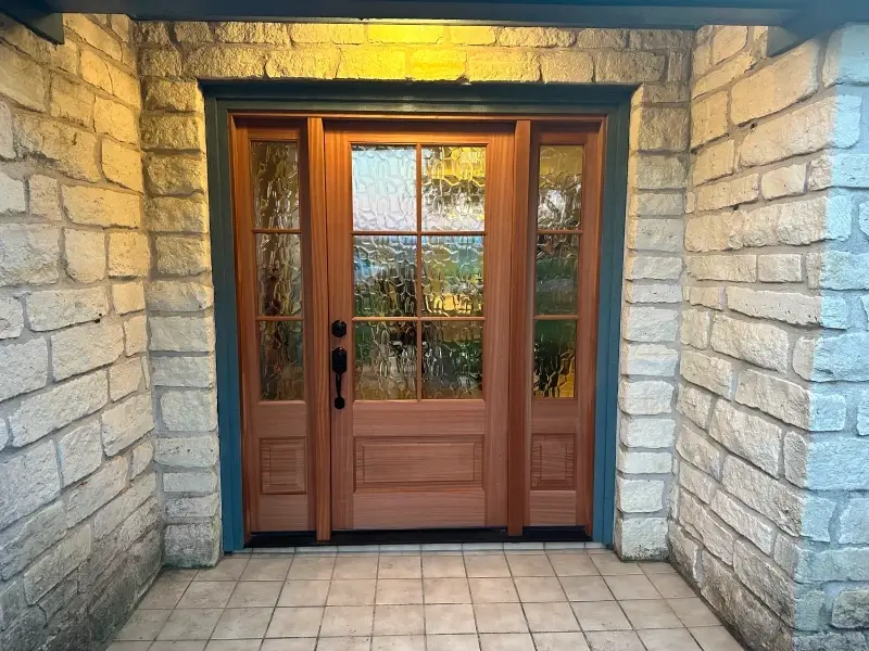 Wooden front door with decorative glass panels.